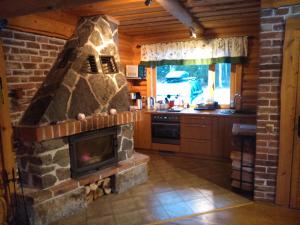 - une cuisine avec une cheminée en pierre dans une cabine dans l'établissement Vana-Laane Puhkemaja, à Otepää