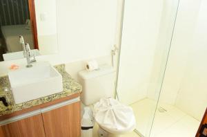 a bathroom with a toilet and a sink and a shower at Resort Encontro das Águas in Caldas Novas +7 photos