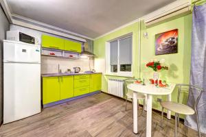a small kitchen with yellow cabinets and a white refrigerator at Apartments on Klovsky descent 20 in Kyiv