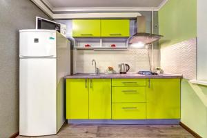 a kitchen with yellow cabinets and a white refrigerator at Apartments on Klovsky descent 20 in Kyiv