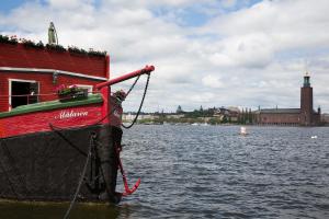 a red boat in a body of water at Den Röda Båten in Stockholm