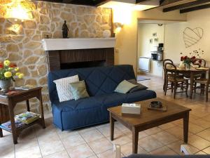 a living room with a blue couch and a fireplace at Gîte des 2 frères in Saint-Pierre-de-Maillé