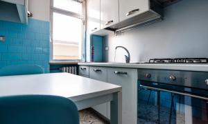 een blauwe en witte keuken met een wastafel en een tafel bij Fly by Suites Pescara in Pescara +20 foto's