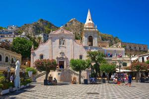 an old church with a mountain in the background at Casa Le Maioliche in Giardini Naxos