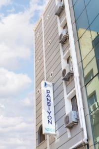 Un cartel de hotel frente a un edificio en Deniz Pansiyon, en Izmir
