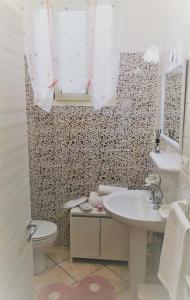 a white bathroom with a sink and a toilet at Casa Le Maioliche in Giardini Naxos