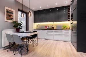 a kitchen with white cabinets and a table and chairs at Elegant Business Accommodation with Parking in Krakow