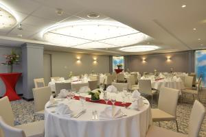 a banquet room with white tables and chairs at Plaza Hotel Capitole Toulouse - Anciennement-formerly CROWNE PLAZA in Toulouse