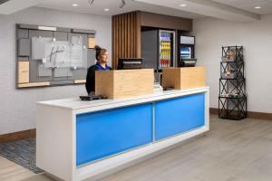 Una donna in piedi al bancone di un ufficio di Holiday Inn Express Hotel & Suites Annapolis, an IHG Hotel ad Annapolis