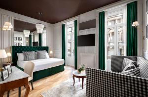 a bedroom with a bed and a living room with chairs at Matilde Boutique Hotel in Milan