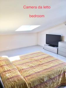 una camera da letto con un letto e una TV a schermo piatto di L'attico di Greta,Etna house a Mascalucia