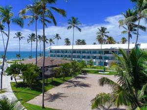 a resort with palm trees in front of the ocean at Excelente Loft Ancorar in Porto De Galinhas