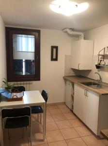 eine Küche mit einem Tisch und Stühlen sowie einem Fenster in der Unterkunft Casa Vacanze Giorgetta 2-3 piano in Chioggia