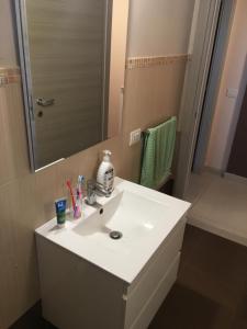 un bagno con un lavandino bianco e uno specchio di L'attico di Greta,Etna house a Mascalucia