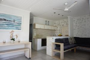 uma sala de estar com um sofá e uma cozinha em 10 Coral Cove em Ballito
