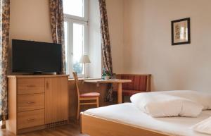 a bedroom with a bed and a flat screen tv at Hotel Angelica in Merano