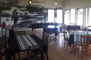 a restaurant with tables and chairs and a painting on the wall at Pousada do Pampa in Jaguarão