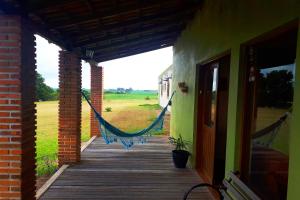 - une terrasse couverte avec un hamac sur le côté du bâtiment dans l'établissement Pousada do Pampa, à Jaguarão