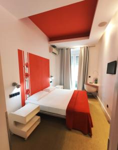 1 dormitorio con 1 cama grande y cabecero rojo en Hostal Santa Ana Colors, en Madrid