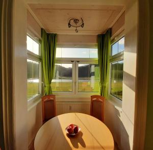 a dining room with a table and two windows at Ferienwohnung Elbsommer am Weinberg in Meißen