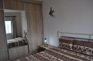 a bedroom with two beds and a mirror at Alp Apartment in Famagusta