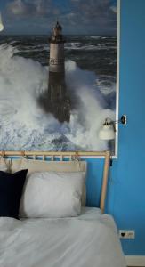 a bedroom with a bed and a lighthouse in the ocean at Lot Lodge Travemünde in Lübeck