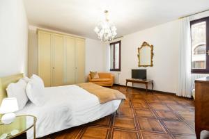 a bedroom with a bed and a couch and a television at Del Remer Apartment - 5mins from San Marco sq in Venice