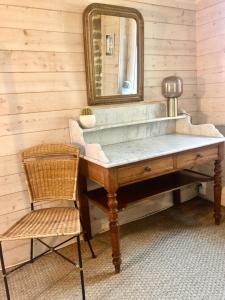 a dressing table with a mirror and a chair at Le Pressoir de la Gervaiserie - 300m de la plage in Réville +18 photos