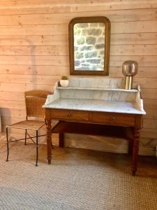 a tub in a room with a mirror and a chair at Le Pressoir de la Gervaiserie - 300m de la plage in Réville