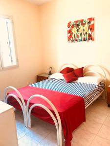 een slaapkamer met een bed met een rode deken erop bij Villetta Leo in Baia Verde in Il Monte
