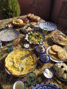 非斯的住宿－Riad Dar Senhaji，餐桌上放有盘子的桌子