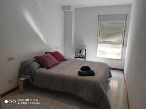 オンティニェントにあるDúplex en Carrer de Sant Jaumeのベッドルーム1室(ベッド1台、ブラックバッグ付)