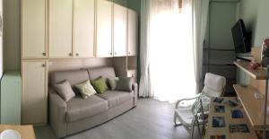 Casa di Alice Luxury Hospitality - Elevator, Fast WiFi في سيراكوزا: غرفة معيشة مع أريكة ونافذة كبيرة