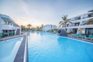 a large swimming pool next to a building at Central location in a great complex with 300mbps internet in Puerto del Carmen