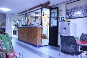 a restaurant with a counter and a table and a refrigerator at Hotel Plaza Aleman in Le&oacute;n