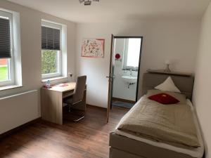 a bedroom with a bed and a desk and a sink at Hotel Stegmann's Hof in Sehnde +15 photos