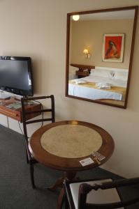 
a living room with a table and a television at Hotel Sussex in Córdoba
