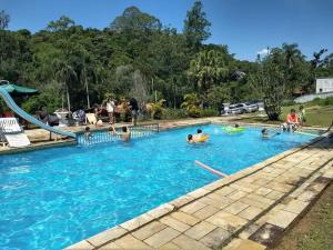 un groupe de personnes jouant dans une piscine dans l'établissement Sítio Zen 37 hectares de flora e fauna preservadas, a 50" da Capital, com wifi 30mbps!, à Mogi das Cruzes