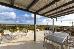 a patio with a table and chairs and a view at Villa Cammarana in Ragusa