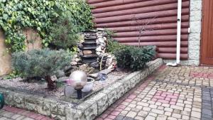 einen Garten mit Pflanzen und einer Steinmauer in der Unterkunft Viktoria in Uschhorod