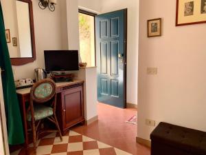 a room with a blue door and a desk with a television at Villino Eleonora in Parghelia