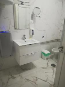 La salle de bains blanche est pourvue d'un lavabo et de toilettes. dans l'établissement Hotel Cristo Rei, à Porto