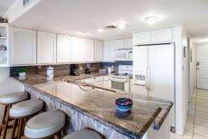 a kitchen with white cabinets and a white refrigerator at Saida Tower I in South Padre Island