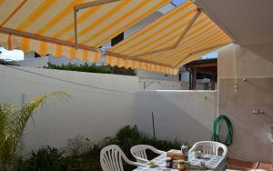 eine Terrasse mit einem Tisch und Stühlen unter einem Sonnenschirm in der Unterkunft Casa a Torre dell Orso Pt55 in Torre dell'Orso