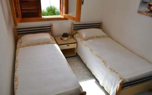 zwei Betten in einem kleinen Zimmer mit Fenster in der Unterkunft Casa a Torre dell Orso Pt55 in Torre dell'Orso