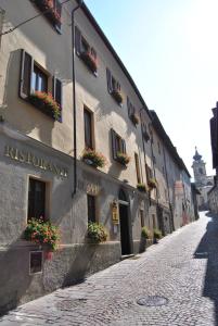 a cobblestone street with a building with flower boxes at Casa Vacanze Oberje dla Viere in Oulx