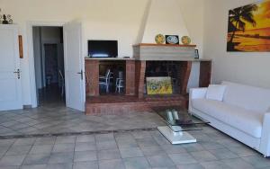 een woonkamer met een bank en een open haard bij Quadrilocale con vista mare Pt51 in Torre dell'Orso