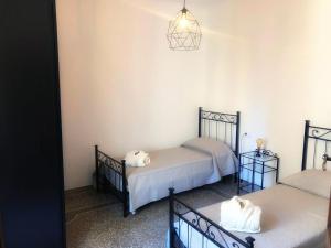 um quarto com duas camas e uma luz pendente em CA’ DEL MARE em Bogliasco