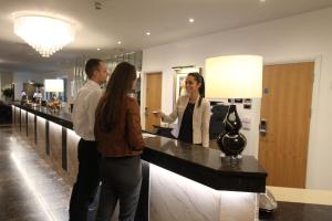 a man and a woman standing at a counter in a store at Belgrave Sands Hotel & Spa in Torquay