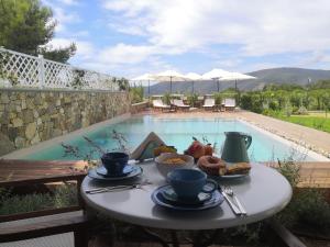 a table with food on it next to a swimming pool at Stile libero b&b in Lacona